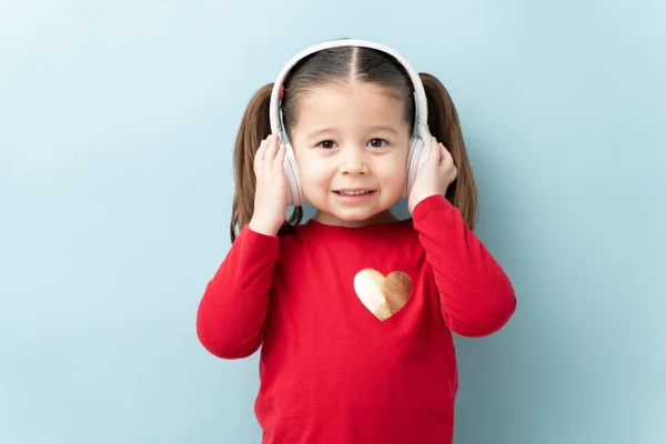 美しい3歳の身に着けているヘッドフォンとスタジオで彼女のお気に入りの曲を聴く — ストック写真