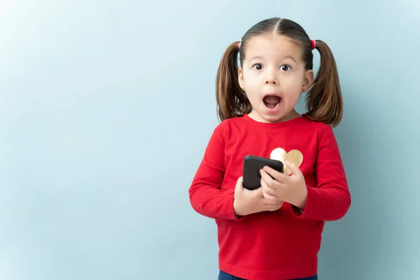 Portrait Beautiful Girl Ponytails Holding Smartphone Looking Shocked Studio — Stock Photo, Image