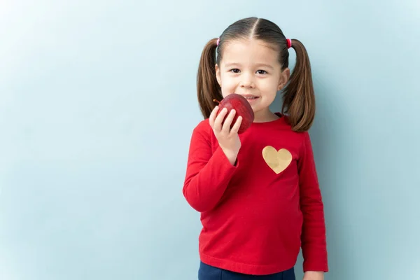 Little Caucasian Girl Ponytails Eating Apple Smiling Studio — Stock Photo, Image