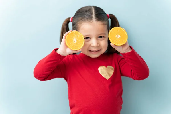 Beautiful Little Girl Holding Two Halves Orange Smiling Blue Background — Stock Photo, Image