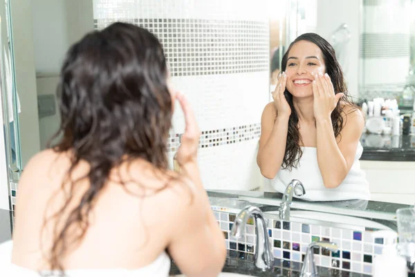 Chica Feliz Usando Poco Crema Facial Frente Espejo Del Baño —  Fotos de Stock