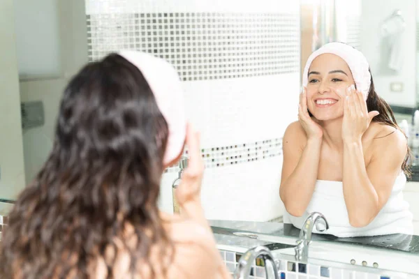 一个30多岁的漂亮女人头戴头巾 在浴室里涂上面霜的画像 — 图库照片