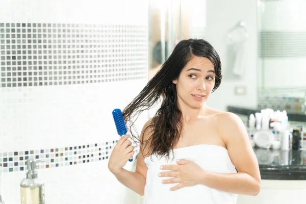 Mulher Bonita Envolto Uma Toalha Escovando Seu Cabelo Emaranhado Banheiro — Fotografia de Stock