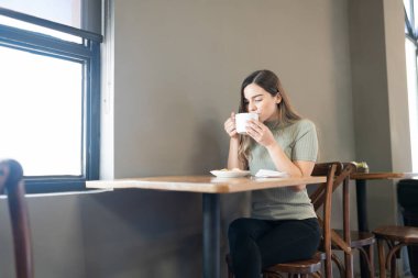 Kafkasyalı tatlı bir kadın fırında ve kafede en sevdiği kahvesinden bir yudum alıyor.