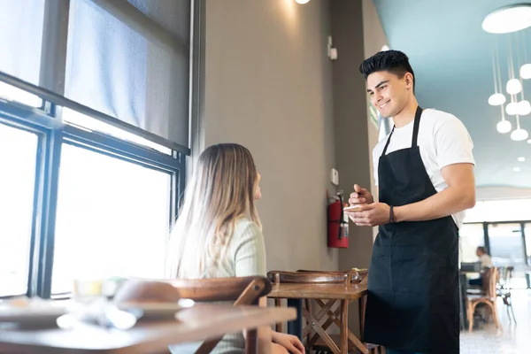 Joven Guapo Anotando Pedido Una Mujer Restaurante Sonriendo —  Fotos de Stock