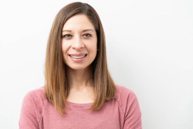 Stüdyoda mutlu görünen güzel esmer bir kadının vesikalığı.