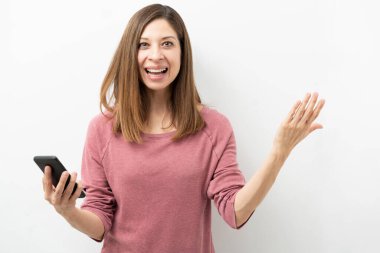 Akıllı telefonuna bakıp şaşırtıcı haberler bulan 40 'lı yaşlarda beyaz bir kadın.