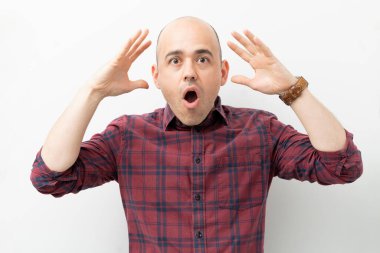 Kafkasyalı kel bir adam ağzı açık şoka uğramış ve şaşırmış görünüyor.