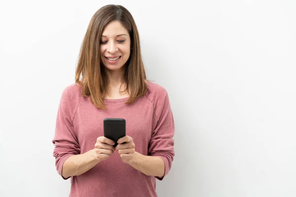 40多岁的白人女性使用智能手机 微笑着看着社交媒体 — 图库照片