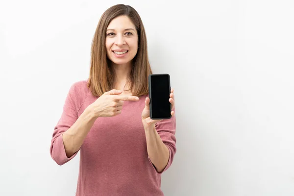 Mooie Vrouw Wijzend Naar Het Scherm Van Haar Smartphone Lachend — Stockfoto