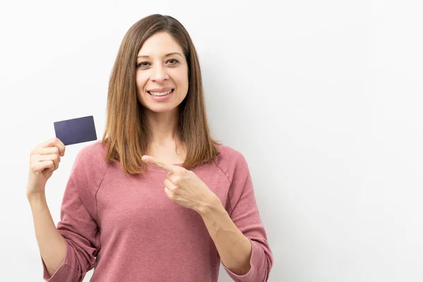Piękna Kobieta Czterdziestce Wskazuje Kartę Kredytową Uśmiecha Się Studiu — Zdjęcie stockowe