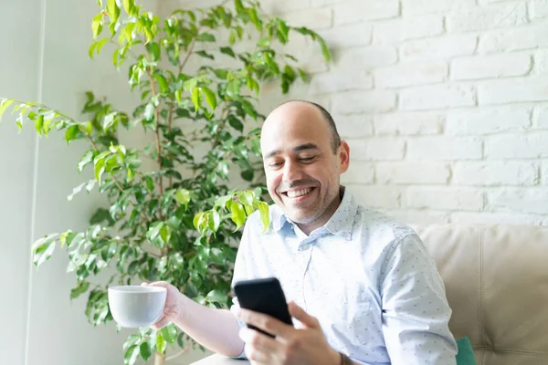 Homem Bonito Seus Anos Olhando Para Smartphone Sorrindo Enquanto Segurando — Fotografia de Stock