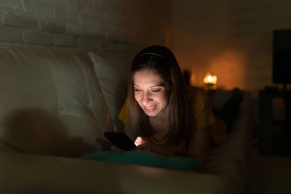 Mooie Vrouw Liggend Een Bank Thuis Kijkend Naar Haar Smartphone — Stockfoto