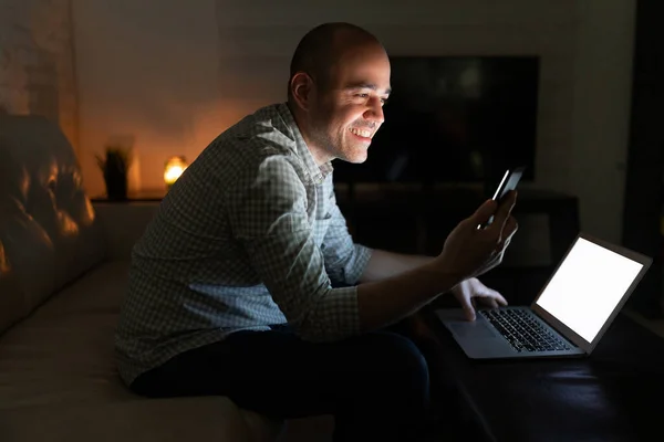 Homem Caucasiano Anos Olhando Para Seu Smartphone Usando Laptop Para — Fotografia de Stock