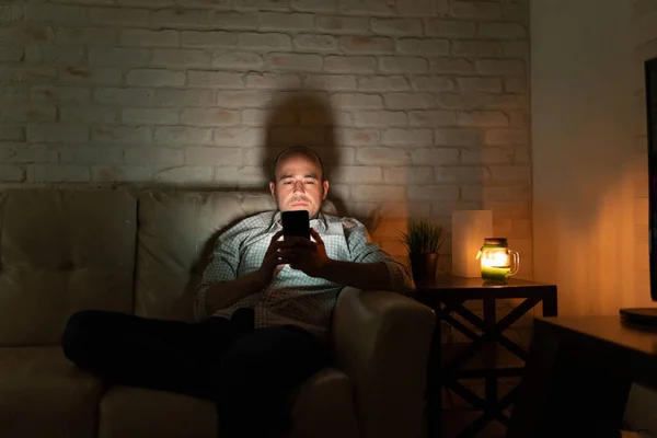 Homem Solitário Anos Sentado Sofá Casa Olhando Para Seu Smartphone — Fotografia de Stock