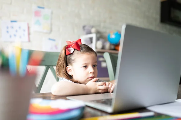 Menina Bonita Sentada Casa Enquanto Assiste Vídeos Computador Portátil — Fotografia de Stock