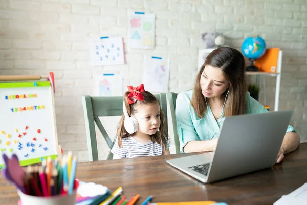 Cute Little Girl Jej Matka Nosi Słuchawki Pomocą Laptopa Niektórych — Zdjęcie stockowe