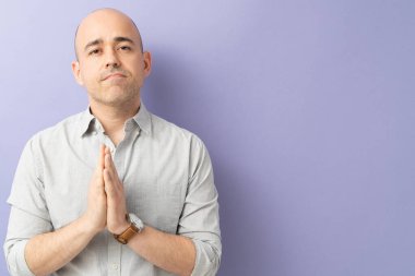 30 'lu yaşlarda bir adamın portresi ellerini birleştiriyor ve bir stüdyoda davasını savunuyor.