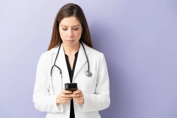 以40多岁的女医生为重点 用智能手机给病人发短信 看上去很严肃 — 图库照片