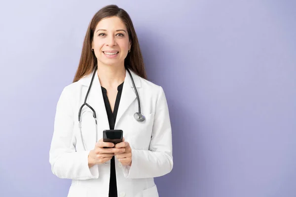 Retrato Una Médica Amigable Usando Teléfono Inteligente Sonriendo Estudio Con —  Fotos de Stock