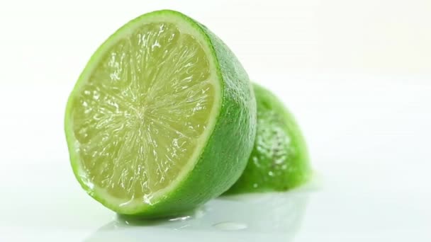 Une lime coupée en deux et disposée sur un fond blanc — Video