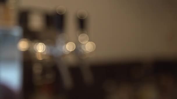 Een pull-focus shot op een bier-tap in een pub — Stockvideo