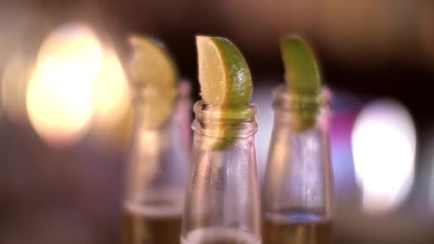 Ein Schuss Limettenscheiben in der Spitze von Bierflaschen — Stockvideo