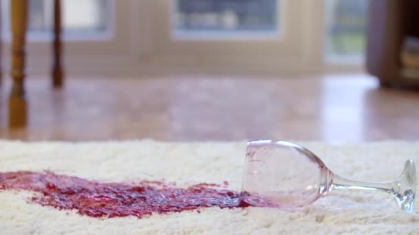 Glass of red wine being dropped on a white rug in slow motion — Stock Video