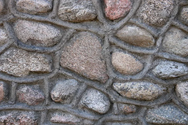 The wall, laid out from the lodges of different shapes. Background — Stock Photo, Image