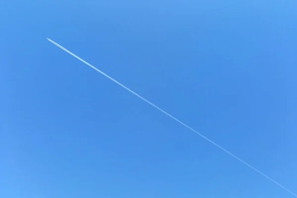 Céu azul brilhante com uma tira de um avião, fundo — Fotografia de Stock