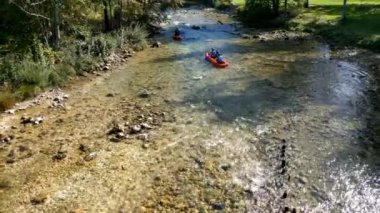 Bohinj, Slovenya - 15 Haziran 2019: Bir grup gencin bir teknede yüzdüğü nehir manzarası.