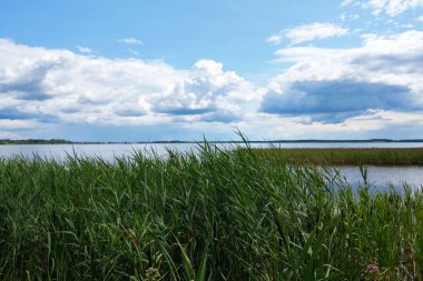 Gökyüzü ve gölün güzel manzarası. Açık bir günde beyaz bulutlar..