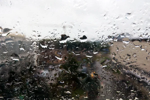 Abstrakter Vollrahmen-Hintergrund, der ein Fenster zeigt, in dem Regentropfen herunterrollen. — Stockfoto