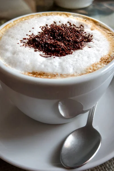 Een kop koffie in een wit kopje op houten achtergrond. — Stockfoto