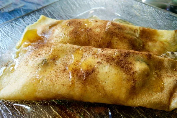 Spring rolls on a transparent plate, drizzled with honey on top. — Stock Photo, Image