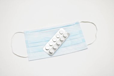 Yüz maskesi ve beyaz haplar. Coronavirus konsepti.