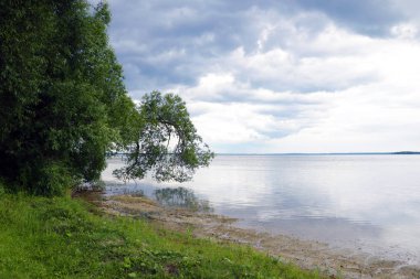 Bulutlu bir günde büyük bir göl ya da denizin kıyısında