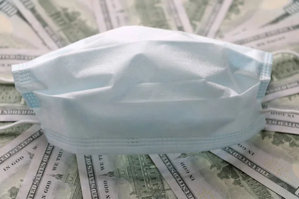 Solunum yollarının virüsten korunmasının bir sembolü olarak dolarların üzerindeki tıbbi maske. Kopyalama için bir yer var.