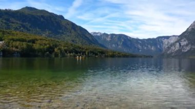 İnsanlar Triglav Ulusal Parkı 'ndaki Bohinj Gölü' nde rafting yapıyorlar. Julian Alpleri 'nden Bohinj Vadisi. Resimli manzara, sonbahar manzarası.