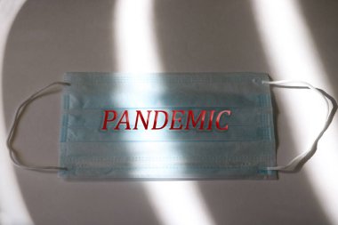 Cerrahi maskeli dramatik bir atmosfer. Tıbbi bir maskeye pandemic yazılıydı. Küresel Salgın Alarmı