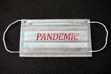 Tıbbi bir maskeye pandemic yazılıydı. Romantik koronavirüs salgını. Covid 'in önlenmesi. Küresel salgın alarmı. Covid-19 tüm dünyaya yayıldı.