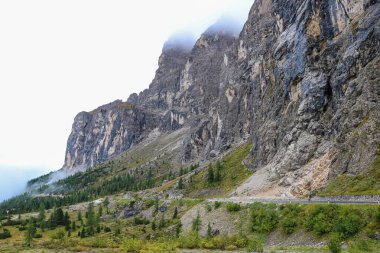 Dolomites Alplerindeki dağ köyünde sisli bir sabah manzarası, seçici bir odak noktası.