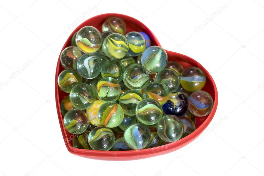 Brightly colored marbles in a heart shaped box
