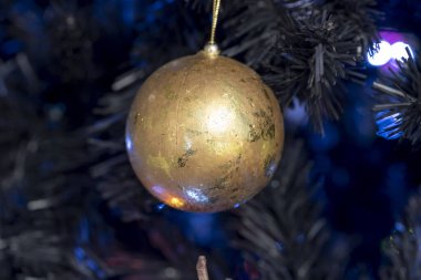 Noel balosu süslemesi parlak bir ışıkla ağaca asıldı.