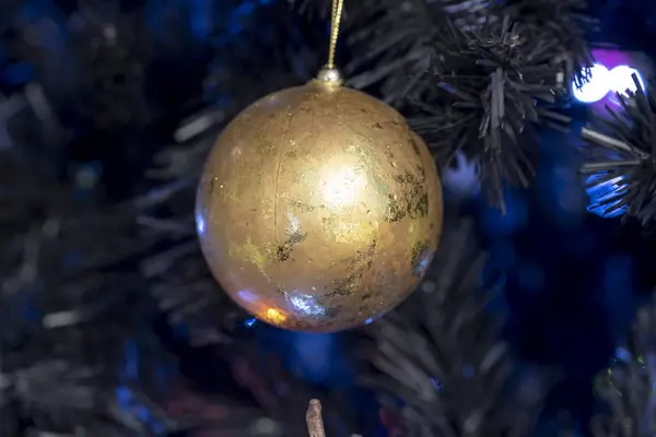 Noel balosu süslemesi parlak bir ışıkla ağaca asıldı.