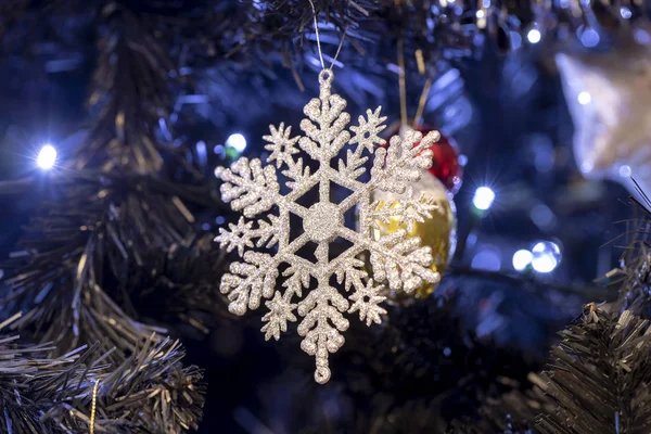 Ağaçta parlak bir parıltıyla kar tanesi Noel süslemesi