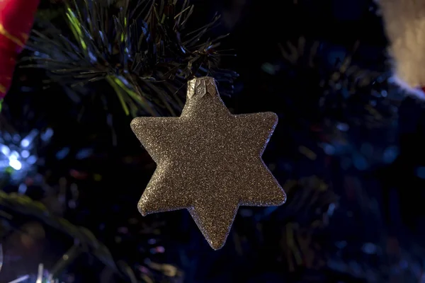 Ağaçta parlayan bir parıltıyla Noel süslemesi yıldızı