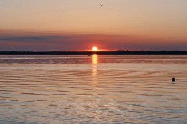 Kırmızı bir gün batımı göl ve bir yat üzerinde