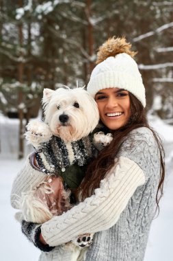 Kışın elinde köpek olan kız.