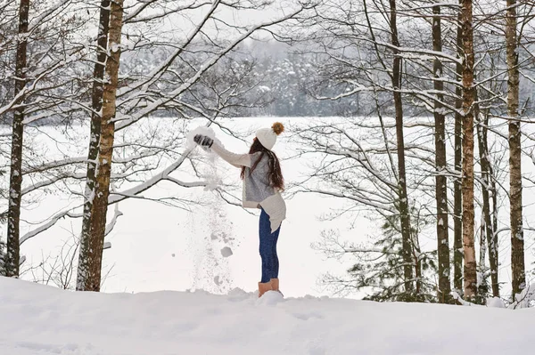 Счастливая красивая брюнетка играет со снегом . — стоковое фото